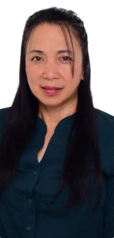 Person with long black hair wearing a dark green button-down shirt.