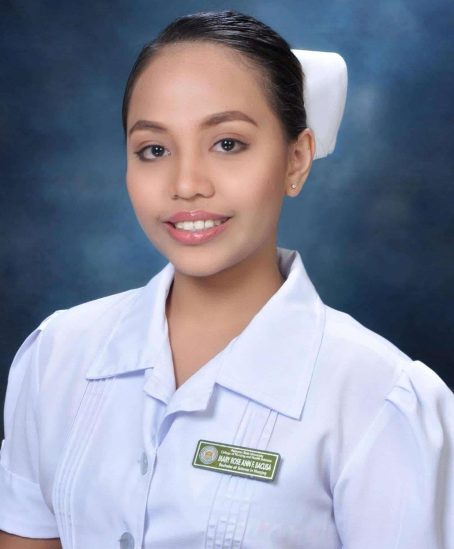 Portrait of a woman in a white uniform with a name tag, smiling against a blue background.